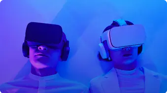 Zwei Personen tragen VR-Headsets und Kopfhörer, beleuchtet von blauem Licht.