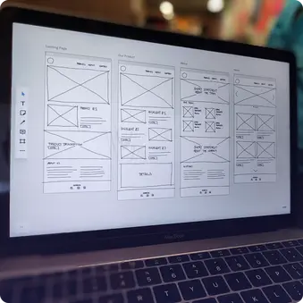 Ein Laptopbildschirm zeigt eine digitale Wireframe-Skizze für eine Website.